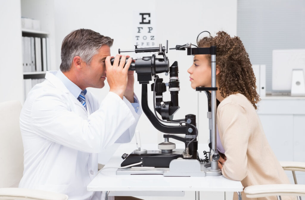 An optometrist checks his patient's eyes in a clinic